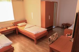 a small room with two beds and a cabinet at Pansion Centar in Tuzla