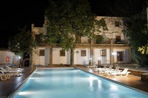 a swimming pool with lounge chairs in front of a building at Hotel Rural Real de Poqueira in Capileira