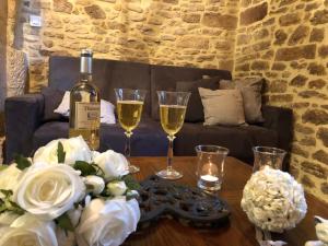 Maison de Charme dans la Cité في سارلا لا كانيدا: زجاجة من النبيذ وكأسين على الطاولة