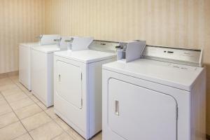 a row of white washers and dryers in a room at Baymont by Wyndham Canton in Canton