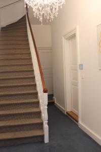un couloir avec un escalier et un lustre dans l'établissement Apartment Creme zentral, à Brême