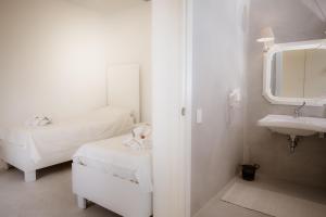 een witte badkamer met 2 bedden en een wastafel bij Le Jardin Potager in Rome