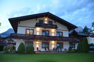 una grande casa bianca con fiori sul balcone di Apartements Birkenhof a Maria Alm am Steinernen Meer