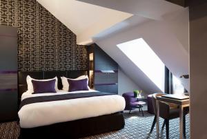 una camera da letto con un letto king size e una scrivania di Le Grey Hotel a Parigi