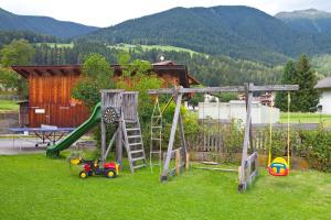 un parque infantil en un patio con un columpio en Marenklhof en Tesido