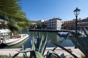 a boat is docked in a river with buildings at Old Harbour House in Grado