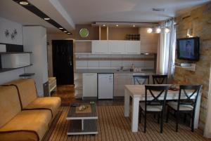 a living room and kitchen with a couch and a table at Villa Milmari in Kopaonik