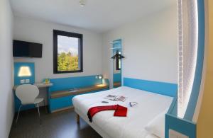 ブロワにあるFirst Inn Hotel Bloisのベッドと机と窓のある部屋