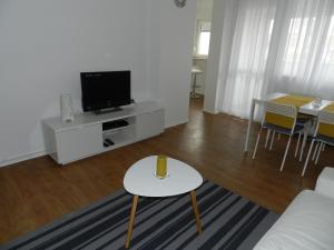 a living room with a couch and a tv and a table at Apartman Perica in Zagreb