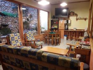 sala de estar con sillas y pared de piedra. en Hostal Casa Barcelo, en Horta de Sant Joan