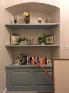 a book shelf with books and plants on it at Dubrovnik Hotel Alternatives in Dubrovnik