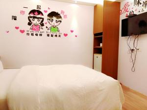 1 dormitorio con 1 cama blanca y TV en Hong Ben Hotel, en Kenting