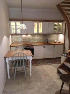 a kitchen with white cabinets and a table and chairs at Dubrovnik Hotel Alternatives in Dubrovnik