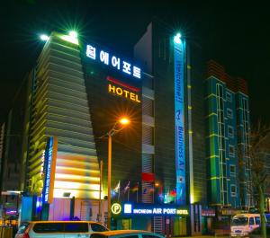 Incheon Airport Hotel في انشيون: فندق في الليل فيه سيارات تقف امامه