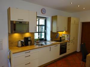 a kitchen with white cabinets and a sink at Haus Geni in Nettetal
