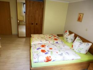 Un dormitorio con una cama con flores. en Abseits vom Lärm und Verkehr, en Litzendorf
