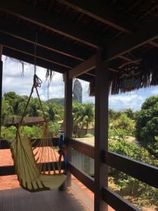 a hammock on the porch of a house with a view at Farol da Rata in Fernando de Noronha