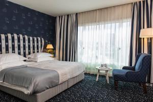 una camera con un letto e una sedia e una finestra di Shalom Hotel & Relax - an Atlas Boutique Hotel a Tel Aviv