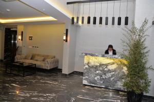 a woman standing behind a counter in a lobby at Gardenya Suite Hotel in Trabzon