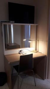 a desk with a lamp and a mirror and a chair at Estrella Lodging in Rabat