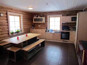 a kitchen with wooden walls and a table in a room at Aasa Puhkemaja in Otepää