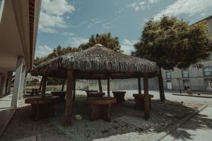 een grote rieten paraplu met krukken en een tafel bij Hotel Quinta dos Cedros in Celorico da Beira