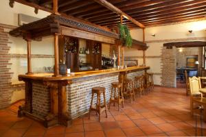 Hotel Real Monasterio de San Zoilo في كاريون دي لوس كونديس: بار في مطعم بجدار من الطوب