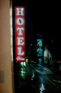 a neon sign on the side of a building at night at Hotel Metohija in Gacko