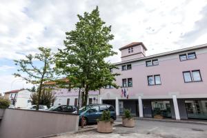 a large white building with a tree in front of it at Best Western Plus Borgolecco Hotel in Arcore