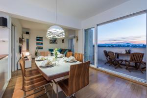 a dining room and living room with a table and chairs at Penthouse with roof terrace with jacuzzi in Zadar
