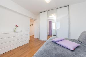 a bedroom with a bed with a purple pillow on it at Penthouse with roof terrace with jacuzzi in Zadar +69 photos