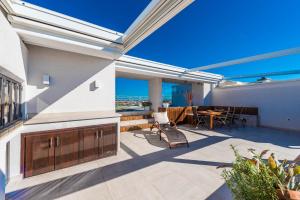 a patio with a table and chairs on a building at Penthouse with roof terrace with jacuzzi in Zadar
