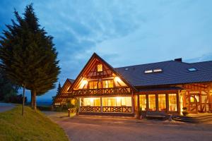 a large wooden house with lights on at Hotel Spinnerhof in Sasbachwalden
