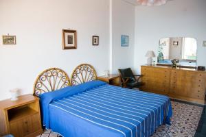 a bedroom with a bed with a blue comforter at Bouganville & Sea in Amalfi