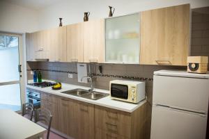 a kitchen with a sink and a microwave at Bouganville & Sea in Amalfi