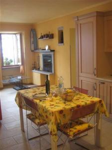 una cucina con tavolo e tovaglia gialla di Il Pergolato a Cannero Riviera