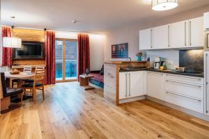 a kitchen with white cabinets and a dining room at Apart Sternenhimmel in Serfaus