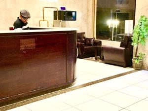 a man sitting at a bar in a waiting room at Najmat Sabbabah Furnished Units in Hail