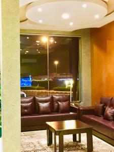 a living room with a couch and a table at Najmat Sabbabah Furnished Units in Hail