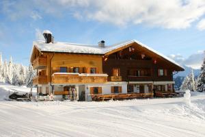 a large wooden house in the snow with snow at Gasthaus Furlhütte in Vipiteno