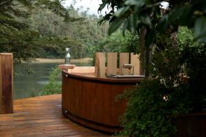 una terraza de madera con un barco con sillas. en Casa Río Vivo, en Valdivia