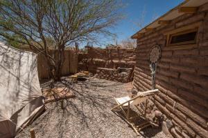 a backyard with a fence and a chair and a building at Aji Verde Hostel San Pedro in San Pedro de Atacama