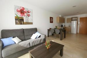 a living room with a couch and a table at Edifici Violetta in Empuriabrava