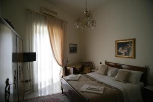 1 dormitorio con 1 cama con lámpara de araña y ventana en Casa Carmen, en Nápoles
