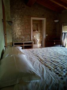 a large bed in a room with a stone wall at Agriturismo Spizzirò in Ponte Nizza