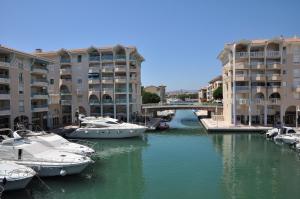 a group of boats docked in a river with buildings at Atoll Hotel restaurant in Fréjus