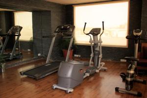 a gym with three tread machines in a room at Udman Hotel Panchshila Park in New Delhi