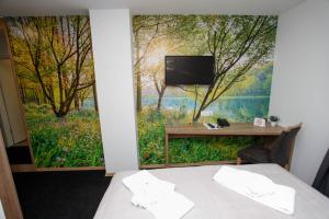 una habitación con una pared con una pintura de un bosque en Hotel Kakanj, en Kakanj