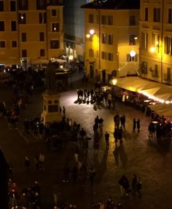 un grupo de personas caminando por la calle por la noche en Sogno Romano, en Roma
