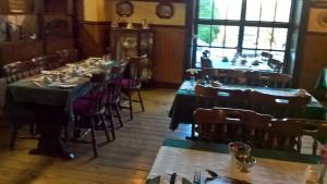 a restaurant with tables and chairs in a room at Rhymney House hotel in Caerphilly